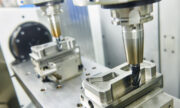 CNC machining cell with two shrinkfit milling tool holders milling the profile of metal parts.